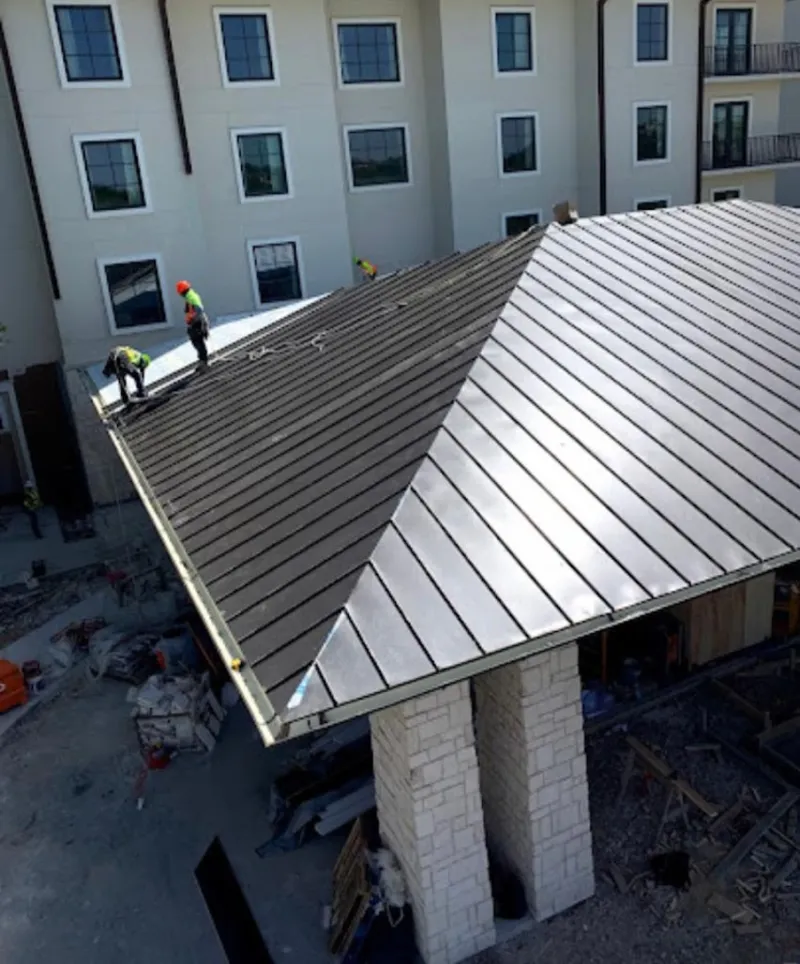 Crew installing standing seam metal roof panels on a commercial project in Plaquemine